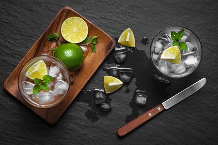 Mojito cocktail with lime and mint in glass on a grey stone backgroundの写真素材