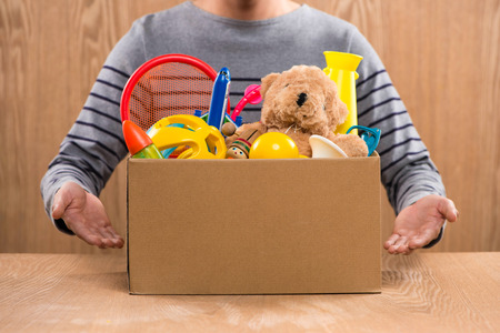 Male volunteer holding donation box with old toys.の写真素材