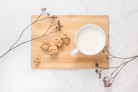 Dairy products. A cup of milk serve with almond candies on a rustic wooden table.の写真素材