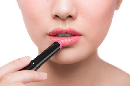 Beautiful young asian woman applying pink lipstickの写真素材