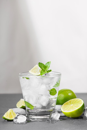 Mojito cocktail with lime and mint in glass on a grey stone backgroundの写真素材
