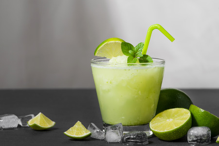 Cocktail juice with lime, mint and ice. Bar drink accessories on black table background.の写真素材