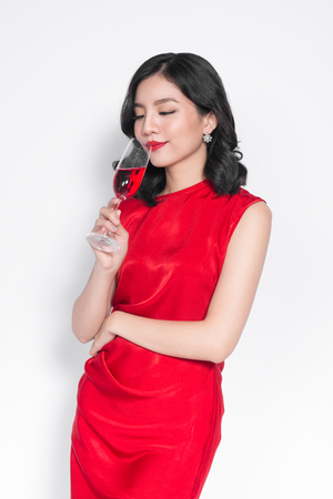 Beautiful asian girl in evening dress smiling holding glass of champagneの写真素材