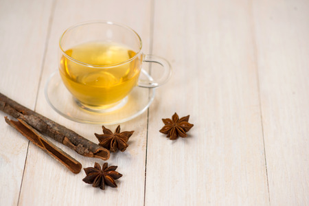 Cup of black tea with spices on white wooden background.の写真素材