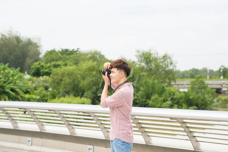 Young asian man taking a photo in cityの写真素材