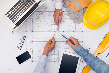 Hands of professional architects discussing and working with blueprintsの写真素材