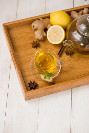 Cup of ginger tea with lemon and honey on white wooden background.の写真素材
