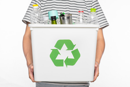 Eco concept. Male hands holding recycling bin full of recyclable items isolated on a white background.の写真素材