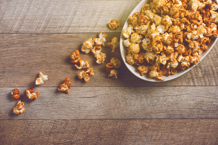 Caramel opcorn in bowl on the wooden table.の写真素材