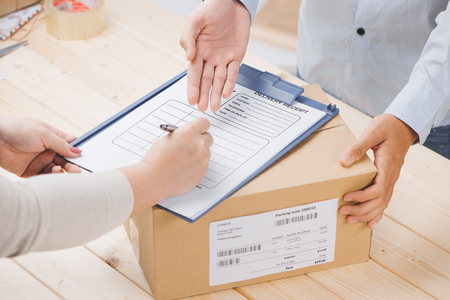 Woman signing receipt of delivery package, close upの写真素材
