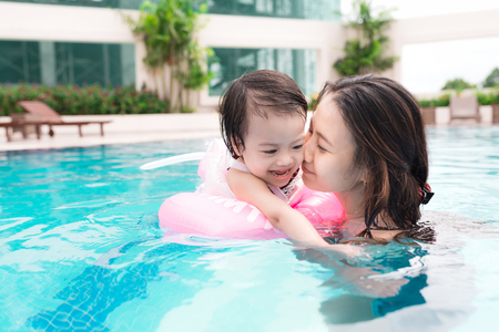 Mother and baby girl having fun in the pool. Summer holidays and vacation conceptの写真素材