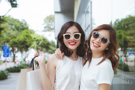 Two beautiful girls window shopping in the cityの写真素材