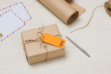 Parcel tied with string with address orange label attachedの写真素材