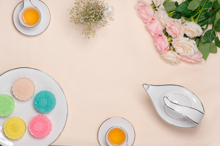 Sweet color of snow skin mooncake. Traditional mid autumn festival foods with tea on table setting.の写真素材