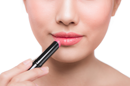 Beautiful young asian woman applying pink lipstickの写真素材