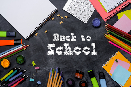 School stationery or office supplies on chalkboard background.の写真素材