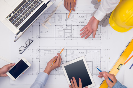 Hands of professional architects discussing and working with blueprintsの写真素材