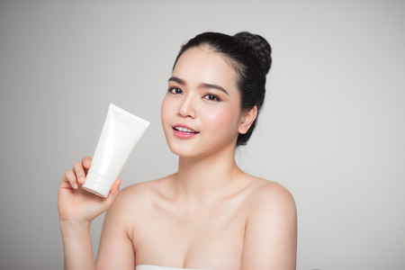 Beauty concept. Asian pretty woman with perfect skin holding cosmetic bottleの写真素材