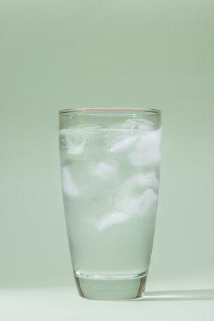 Ice drinking water glass on table over green.の写真素材