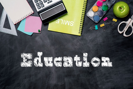 School stationery or office supplies on chalkboard background.の写真素材