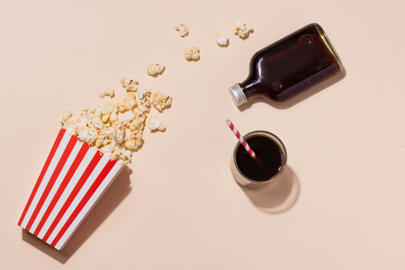 Popcorn in red and white cardboard with glass of sodaの写真素材