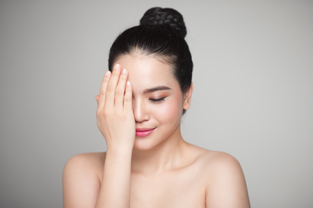 Happy smiling beautiful asian woman touching her face.の写真素材