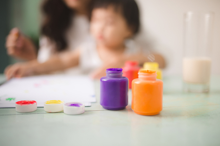 Happy family mother and daughter together paint. Asian woman helps her child girl.の写真素材