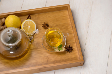 Cup of ginger tea with lemon and honey on white wooden background.の写真素材