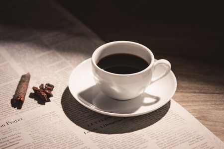 Male hands holding a cup of coffee over wooden table.の写真素材