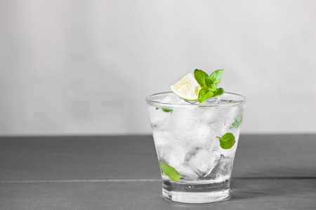 Mojito cocktail with lime and mint in glass on a grey stone backgroundの写真素材