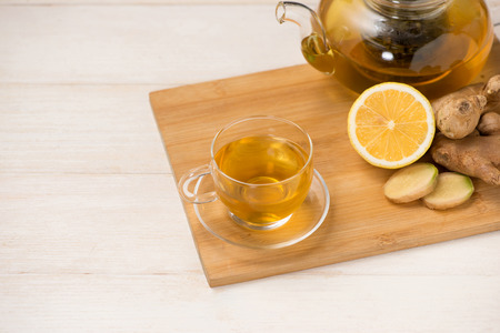 Cup of ginger tea with lemon and honey on white wooden background.の写真素材