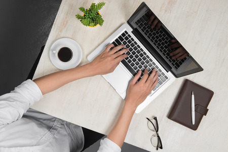 Top view of man using a modern portable computer in home officeの写真素材
