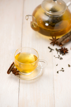 Cup of black tea with spices on white wooden background.の写真素材