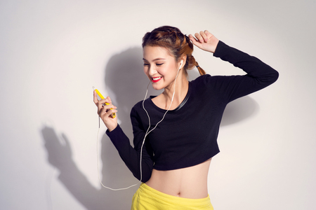Fashion lifestyle portrait of young happy pretty woman listening favorite music,stylish vintage outfit. white backgroundの写真素材