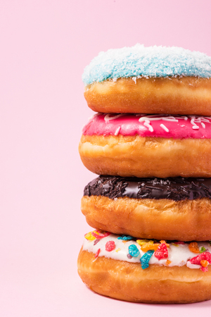 Delicious donuts for birthday on pastel pink background.の写真素材