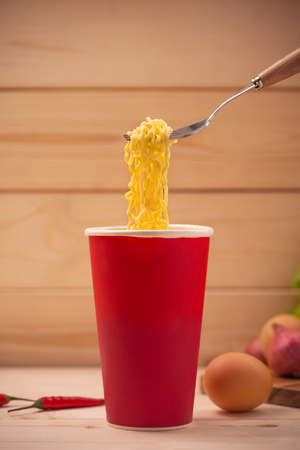 Eating Instant noodles in cup with a forkの写真素材