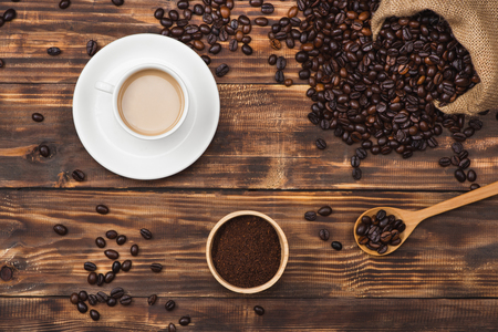 Coffee beans in spoon and cup of hot drinkの写真素材