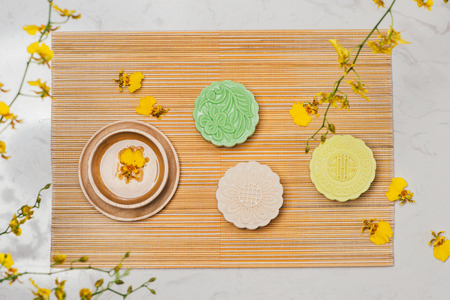 Sweet color of snow skin mooncake. Traditional mid autumn festival foods with tea on table setting.の写真素材