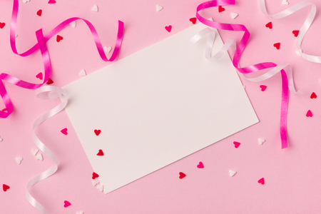 Delicate pink party background with streamers for celebrating with scattered confettiの写真素材