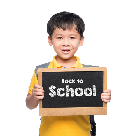 Young asian boy smile holding BACK TO SHCOOL chalkboard over whiteの写真素材