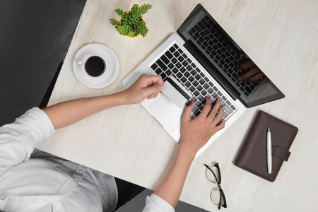 Top view of man using a modern portable computer in home office shopping with credit cardの写真素材