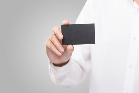 Hand holding blank plain black business card design mockupの写真素材