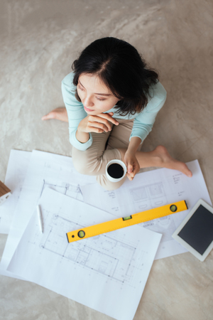 Happy pretty housewife holding new house interior sketch paperの写真素材