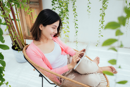 Young pretty woman sitting at home and using digital tablet.の写真素材