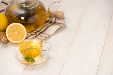 Cup of ginger tea with lemon and honey on white wooden background.の写真素材