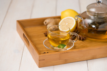 Cup of ginger tea with lemon and honey on white wooden background.の写真素材