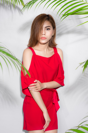 Beauty summer. Beautiful asian woman between palm leaves.の写真素材