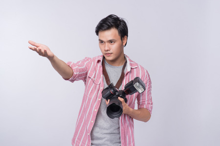 Young asian photographer holding digital camera, while working in studioの写真素材