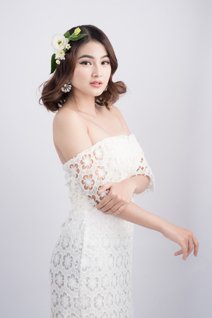 Beautiful asian woman bride on grey background. Closeup portraits with a professional makeupの写真素材