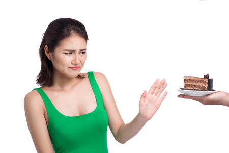 Sad face of asian young woman do not like cake isolated on white background.の写真素材